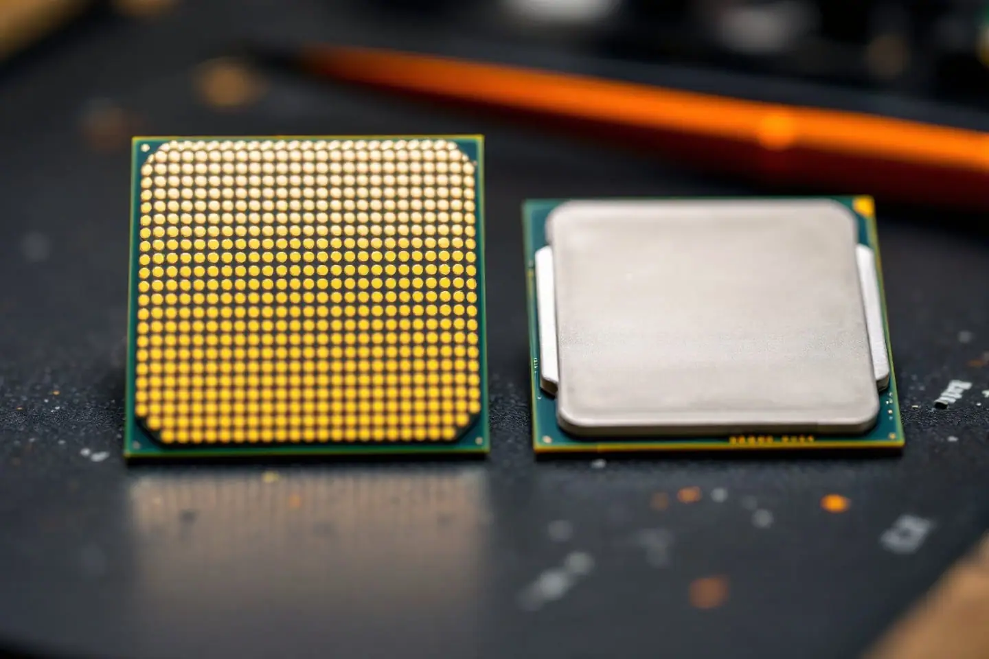 Two processors on an anti-static mat, one flipped over to show its gold contact pads
